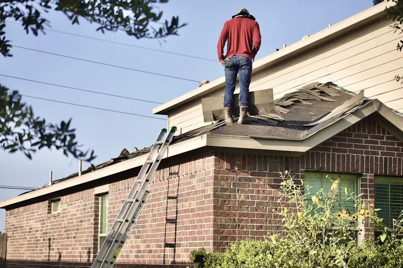 Professional roofer working on a residential roof in Hartselle